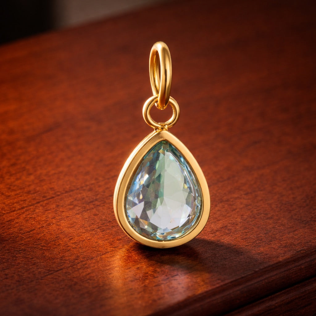 Gold pendant with a clear gemstone on a wooden surface