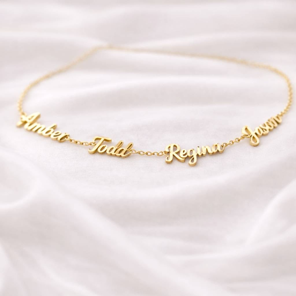 Personalized gold name necklace on white satin fabric