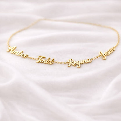 Personalized gold name necklace on white satin fabric