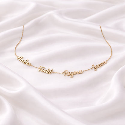 Customized gold name necklace on a white satin backdrop