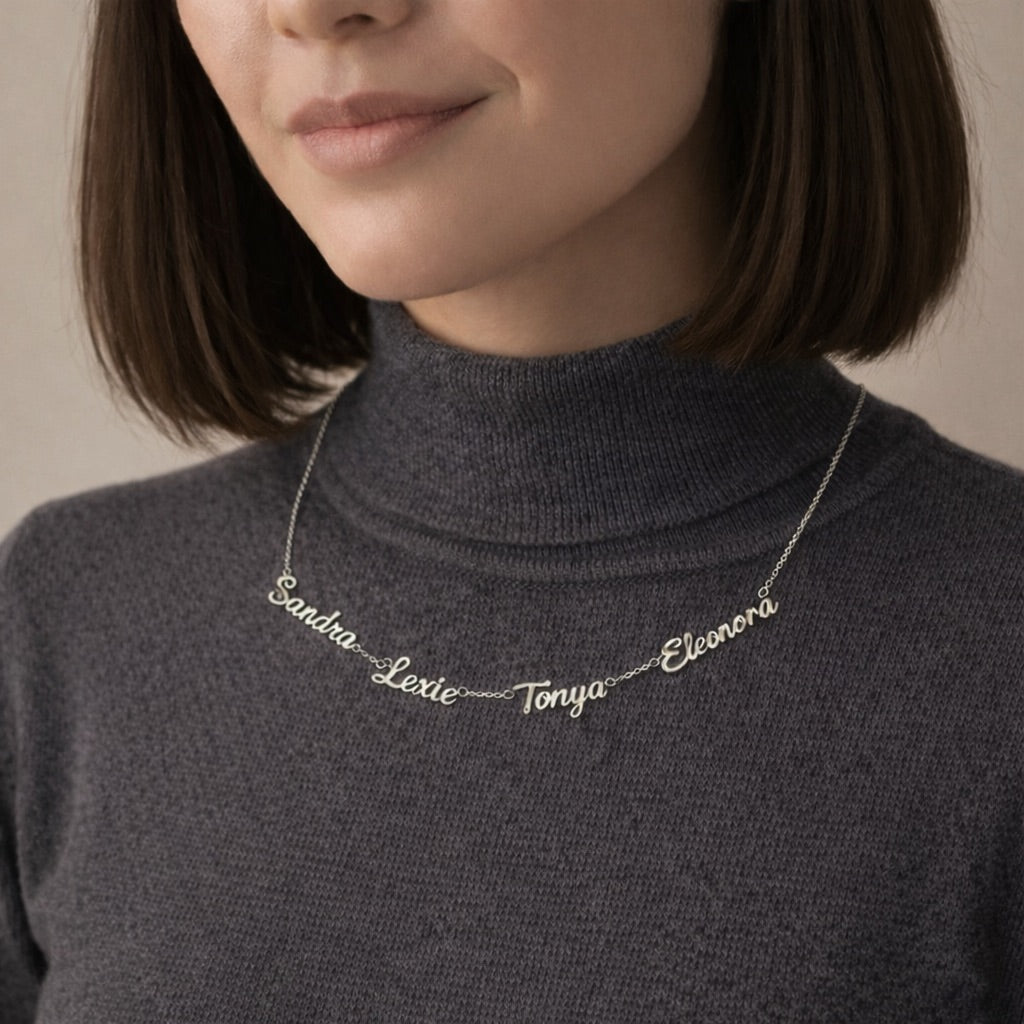 Necklace with engraved names on a person wearing a dark turtleneck